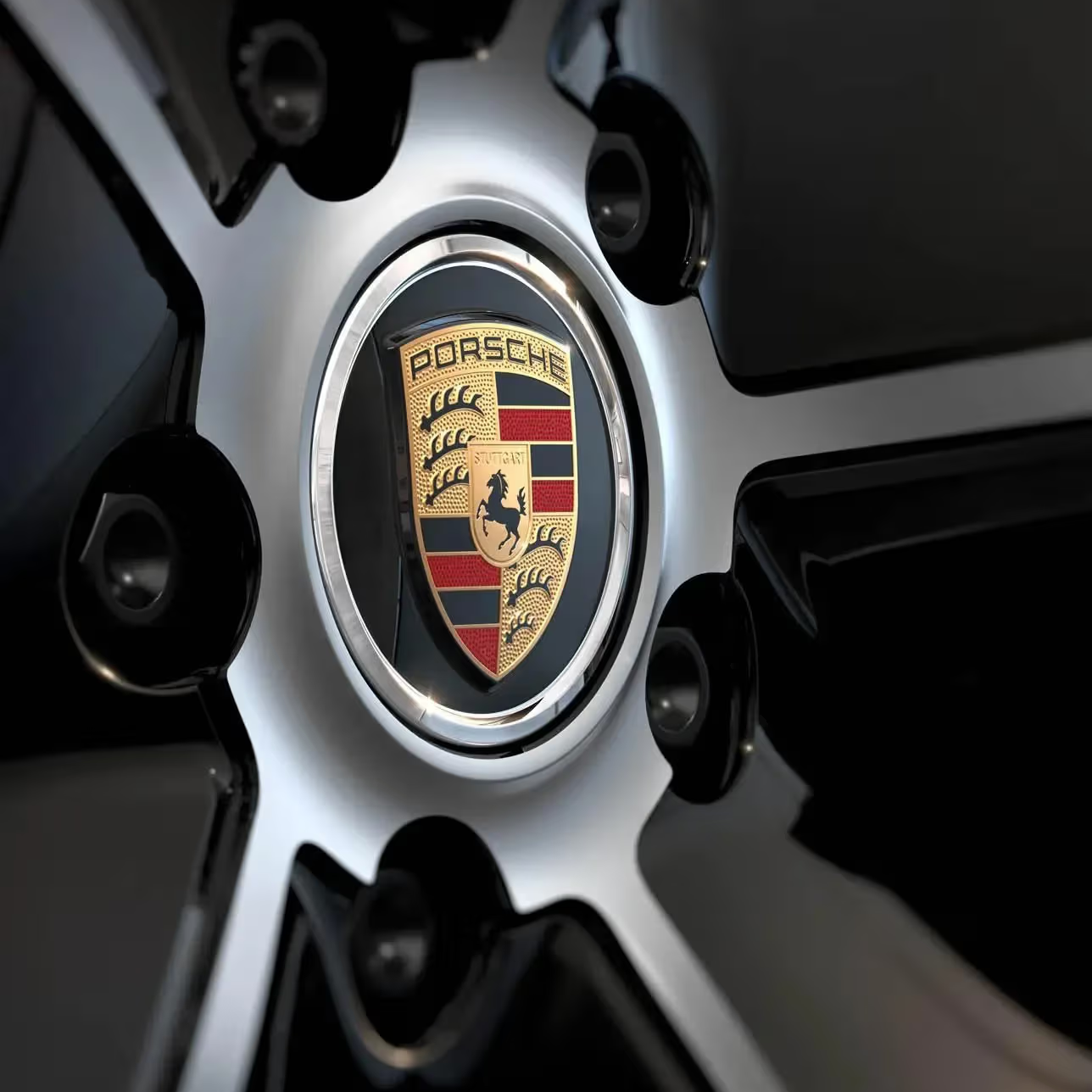 Close-up of a Porsche car wheel rim with the brand logo.